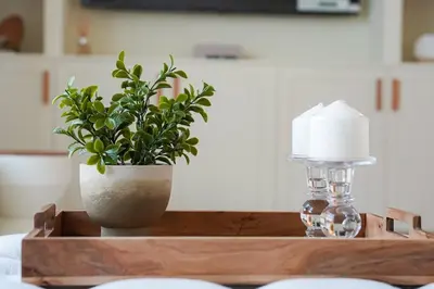 a wooden table with a plant and a lamp on it at Luxe JLT 1BR Apt Gym Pool & Stunning Views in Dubai