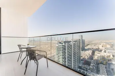 a balcony with a table and chairs in a building at City Views 1BR Near Community Park with Private Balcony, Binghatti House, Jumeirah Village Circle by Deluxe Holiday Homes in Dubai