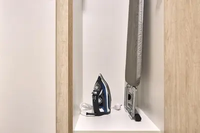 a iron on a shelf next to a tv at Family-Friendly 2BR Apartment in Dubai South at MAG-565 near EXPO and Al Maktoum Airport DWC in Dubai