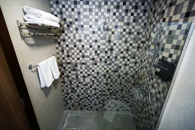 a bathroom with a shower with black and white tiles at Your comfy stylish studio in Dubai 2guest and baby in Dubai