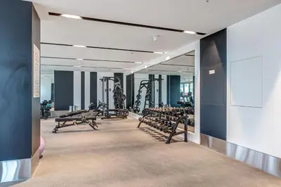a gym with rows of treadmills and machines at Stylish New Apt, Minutes from Downtown Dubai in Dubai