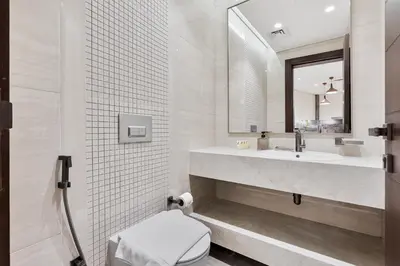 a bathroom with a sink and a toilet and a mirror at Stylish New Apt, Minutes from Downtown Dubai in Dubai