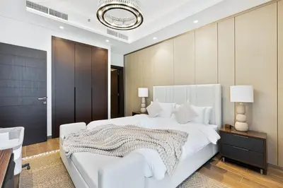 a bedroom with a large white bed and a mirror at Stylish New Apt, Minutes from Downtown Dubai in Dubai