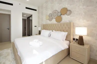 a bedroom with a large white bed with towels on it at Modern 2 bedroom in Binghatti Crescent JVC- Truebleu vacation homes in Dubai