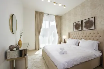 a bedroom with a large white bed and a window at Modern 2 bedroom in Binghatti Crescent JVC- Truebleu vacation homes in Dubai