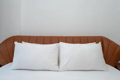 two white pillows on a bed with a brown headboard at Luxury 2-Bed Retreat with Stunning Creek Views in Dubai