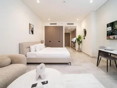 a bedroom with a bed and a living room at Luxury Studio in Peninsula Five, Business Bay in Dubai