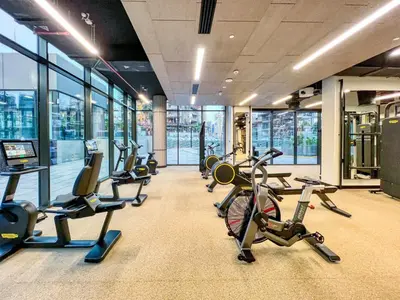 a gym with a bunch of exercise bikes and ellipticals at Luxury Studio in Peninsula Five, Business Bay in Dubai