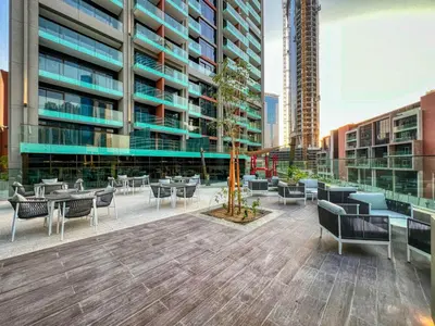 a patio with tables and chairs in front of a building at Luxury Studio in Peninsula Five, Business Bay in Dubai