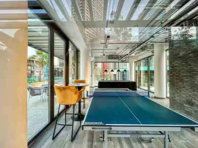 a ping pong table in a room with windows at Luxury Studio in Peninsula Five, Business Bay in Dubai