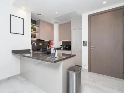 a kitchen with a counter with a trashcan in it at Brand New Business Bay 1 Bed with Burj Khalifa and Canal Views in Dubai