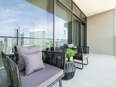 a balcony with chairs and a view of the city at Brand New Business Bay 1 Bed with Burj Khalifa and Canal Views in Dubai