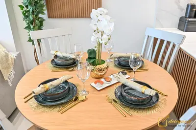 a wooden table with black plates and wine glasses at Marvelous 1BR in Binghati Amber by deleguest in Dubai
