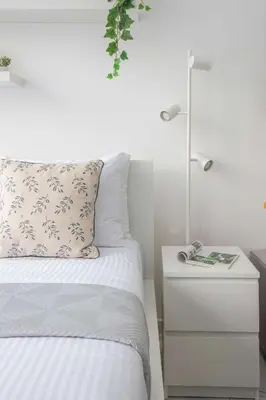 a bedroom with a bed and a nightstand with a lamp at Frank Porter - Serenity Lakes 5 in Dubai