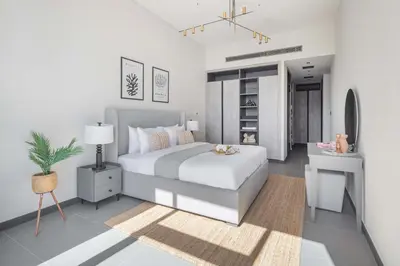 a bedroom with a king sized bed and a table at Frank Porter - MBL Royal in Dubai