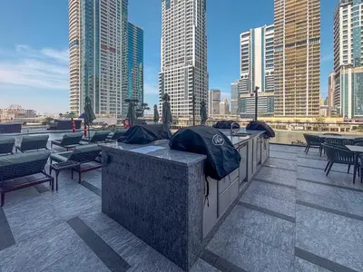 a rooftop patio with tables and chairs and buildings at Frank Porter - MBL Royal in Dubai