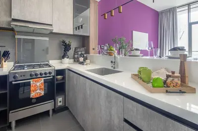 a kitchen with a stove and a sink and purple walls at Frank Porter - MBL Royal in Dubai