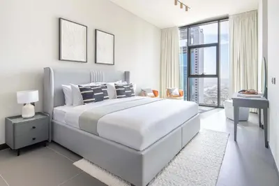 a white bedroom with a large bed and a window at Frank Porter - MBL Royal in Dubai