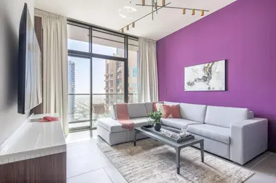 a living room with purple walls and a couch and a table at Frank Porter - MBL Royal in Dubai