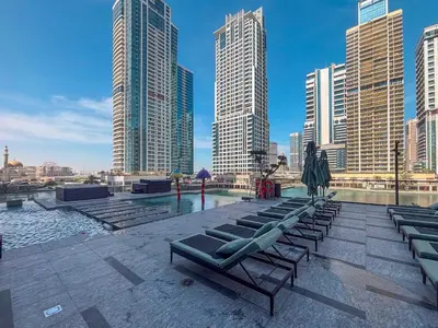a row of chaise lounges in a city with tall buildings at Frank Porter - MBL Royal in Dubai