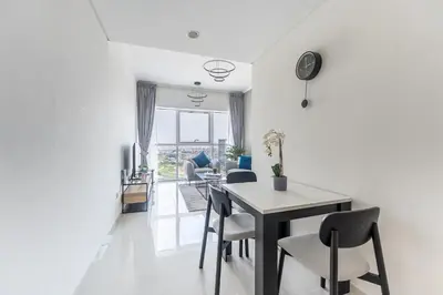a dining room and living room with a table and chairs at HAVN - 1 Bed in Damac Hills 1, Golf Course View in Dubai