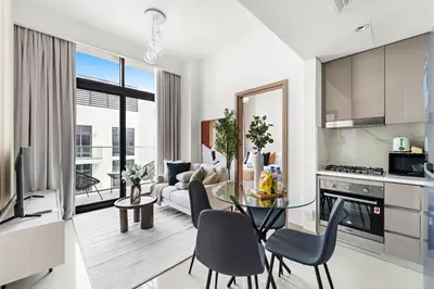 a kitchen and living room with a table and chairs at Silkhaus Stylish 2BDR in Azizi Gardens with Pool & Gym in Dubai