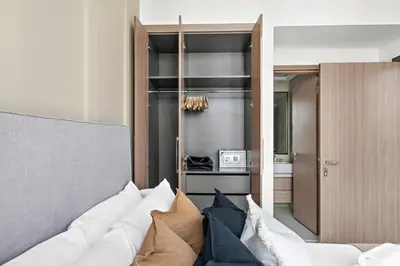 a living room with a white couch with pillows at Silkhaus Stylish 2BDR in Azizi Gardens with Pool & Gym in Dubai