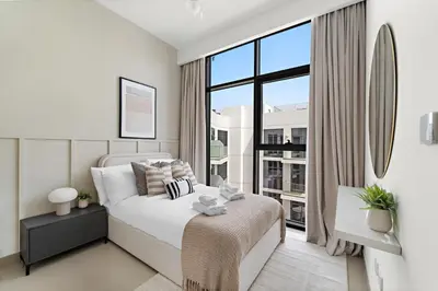a bedroom with a bed and a large window at Silkhaus Stylish 2BDR in Azizi Gardens with Pool & Gym in Dubai