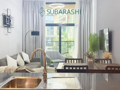 a living room with a couch and a table at Stylish 1BR Apartment in JVC in Dubai