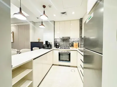a kitchen with white cabinets and a stainless steel refrigerator at Vserve I 1 BR - Luxury Escape in Business Bay in Dubai