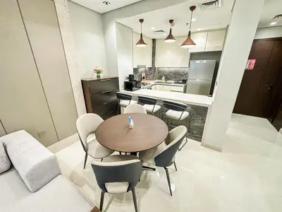 a dining room with a table and chairs and a kitchen at Vserve I 1 BR - Luxury Escape in Business Bay in Dubai