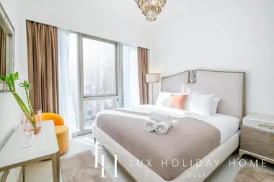 a bedroom with a bed with two towels on it at LUX The Grande Signature Skyline Suite in Dubai