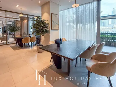 a dining room with a wooden table and chairs at LUX The Grande Signature Skyline Suite in Dubai