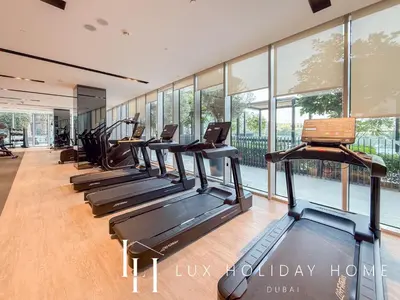 a row of treadmills in a gym with windows at LUX The Grande Signature Skyline Suite in Dubai