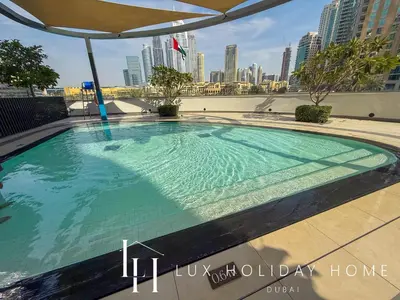 a swimming pool with a city skyline in the background at LUX The Grande Signature Skyline Suite in Dubai