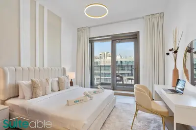 a hotel room with a bed and a desk and a window at Chic 1Bedroom with Stunning Marina View in Sparkle in Dubai