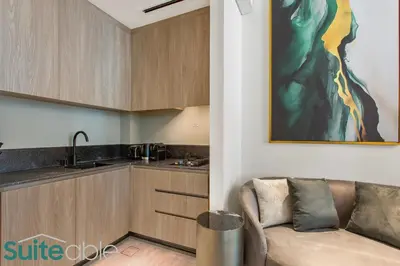 a living room with a couch and a kitchen at Sophisticated Studio in The Autograph in Dubai
