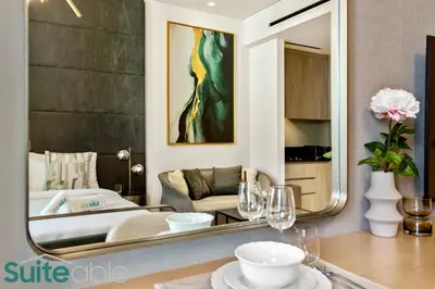 a living room with a bed and a large mirror at Sophisticated Studio in The Autograph in Dubai