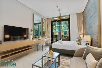 a living room with a bed and a tv at Chic Studio with Pool Access in The Autograph in Dubai