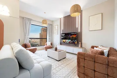 a living room with a white couch and a fireplace at KYMA 2BDR JBR - Luxury Apartment with Full Panoramic Dubai Marina view in Dubai