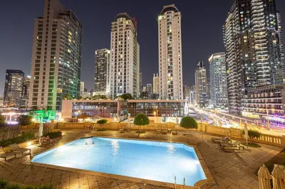 a pool in a city at night with tall buildings at KYMA 2BDR JBR - Luxury Apartment with Full Panoramic Dubai Marina view in Dubai