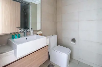 a bathroom with a sink and a toilet and a mirror at Frank Porter - Azizi Riviera 28 in Dubai