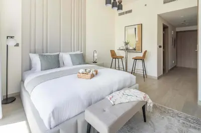 a bedroom with a large white bed and a table at Frank Porter - Azizi Riviera 28 in Dubai