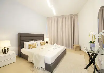 a white bedroom with a large bed and a window at Stylish 2BR in Bellevue Pool, Gym & Burj Views in Dubai
