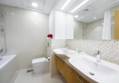 a bathroom with a sink and a toilet and a mirror at Stylish 2BR in Bellevue Pool, Gym & Burj Views in Dubai