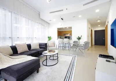 a living room with a couch and a table at Stylish 2BR in Bellevue Pool, Gym & Burj Views in Dubai
