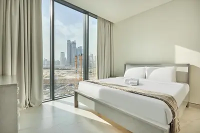 a bedroom with a large bed and a large window at STAY BY LATINEM Luxury 1BR Holiday Home CVG 710 Near Burj Khalifa in Dubai