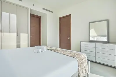 a bedroom with a white bed and a mirror at STAY BY LATINEM Luxury 1BR Holiday Home CVG 710 Near Burj Khalifa in Dubai
