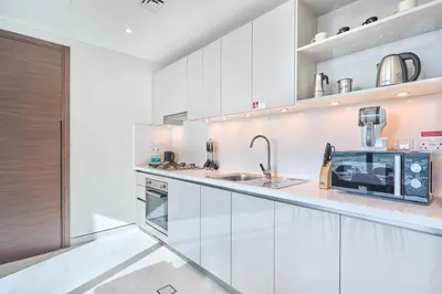 a kitchen with white cabinets and a sink at STAY BY LATINEM Luxury 1BR Holiday Home CVG 710 Near Burj Khalifa in Dubai