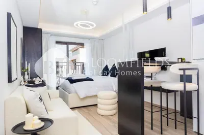 a bedroom with a bed and a living room at Bloomfields Modern Escape STU In JVC in Dubai